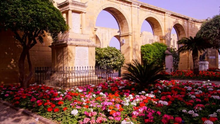 Jardins d’Upper Barrakka à La Valette avec massifs fleuris et arcades.