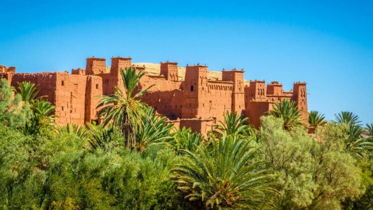 Kasbah traditionnelle entourée de palmiers dans le sud du Maroc.