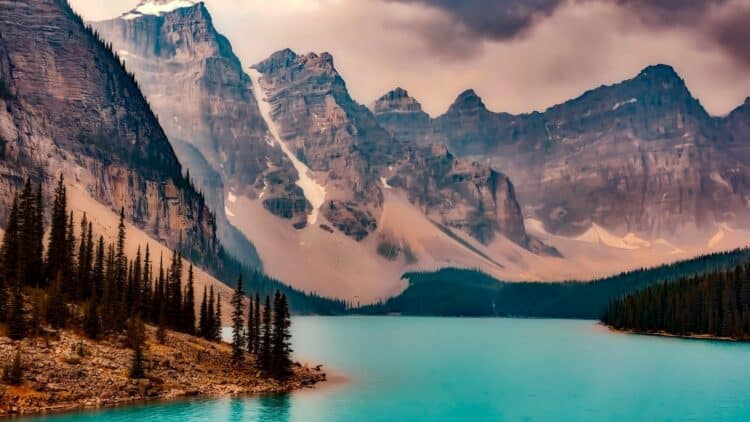 Lac turquoise entouré de montagnes dans les Rocheuses canadiennes.