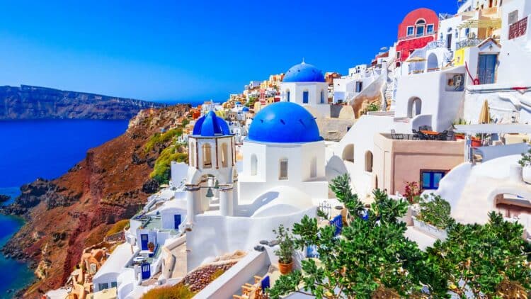 Églises aux dômes bleus et maisons blanches à Oia, sur l’île de Santorin en Grèce.