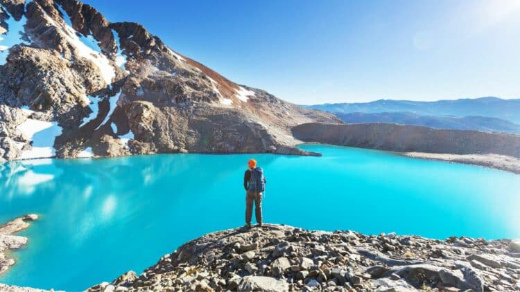 Randonneur face à un lac turquoise de montagne dans les paysages de Patagonie argentine.