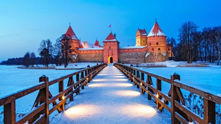 Château de Trakai enneigé relié par une passerelle au cœur de l’hiver en Lituanie.