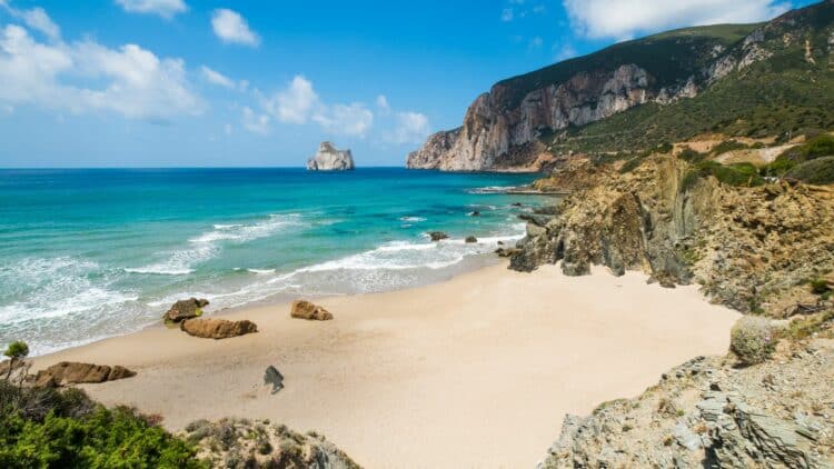 Plage de sable clair et falaises sur la côte de Sardaigne, en Italie.