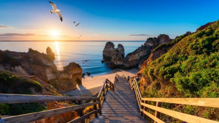 Escalier menant à une plage bordée de falaises dans l'Algarve au Portugal.