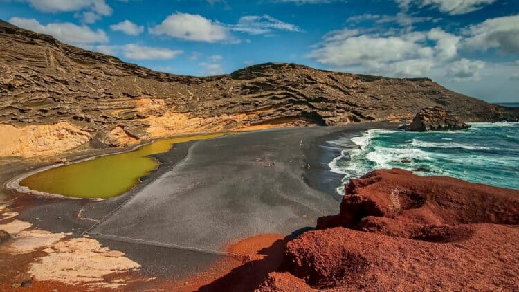 Plage de sable noir et lagune sur la côte volcanique de Lanzarote.