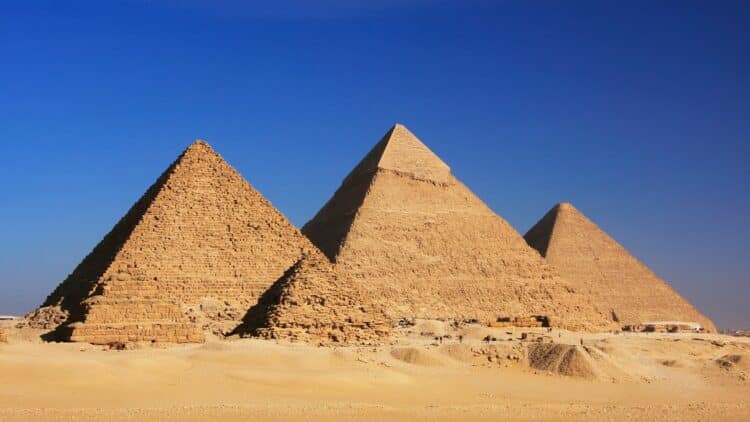 Les pyramides de Gizeh dans le désert égyptien sous un ciel bleu.