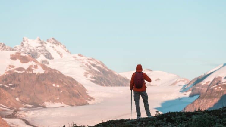 Randonneur contemplant un glacier dans les montagnes d'Alaska.