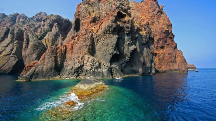 Falaises volcaniques et eaux cristallines de la réserve naturelle de Scandola en Corse.