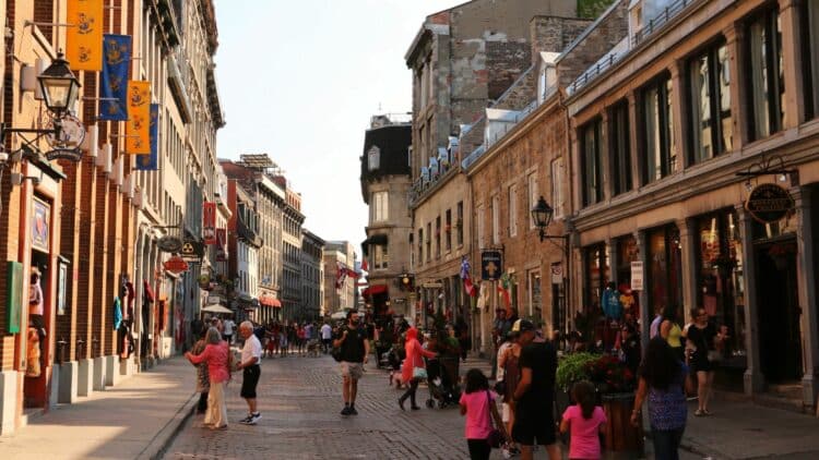 Rue animée du Vieux-Montréal bordée de bâtiments historiques.