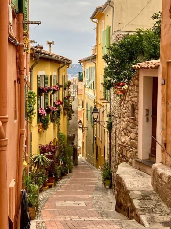 Ruelle pavée bordée de maisons colorées dans la vieille ville de Menton, sur la Côte d’Azur.
