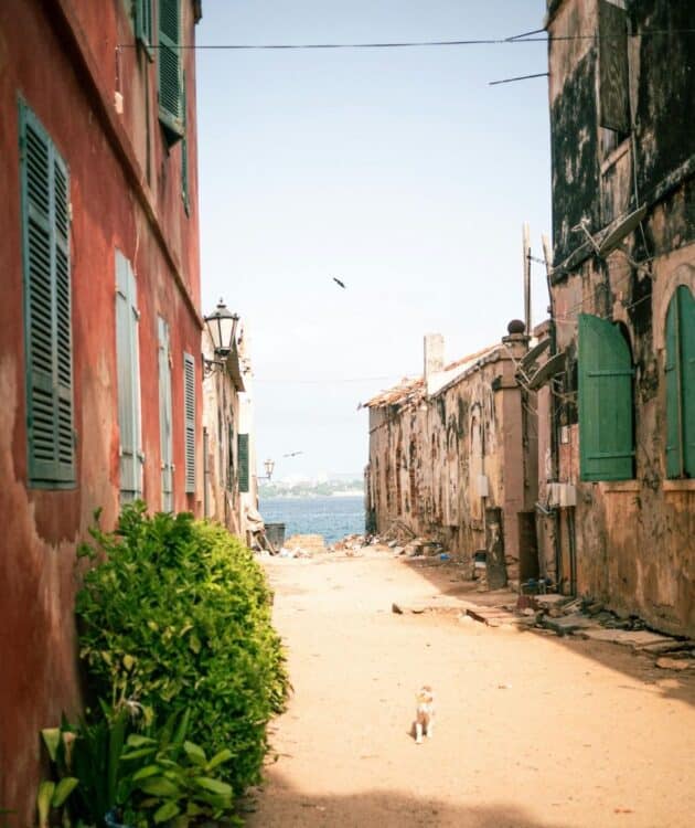 Ruelle ancienne de l’île de Gorée avec vue sur la mer.