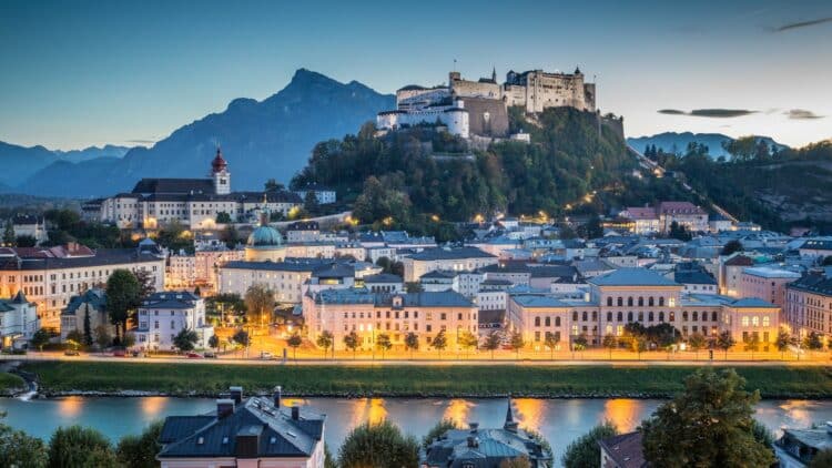 Vue sur Salzbourg et sa forteresse dominant la ville au coucher du jour.