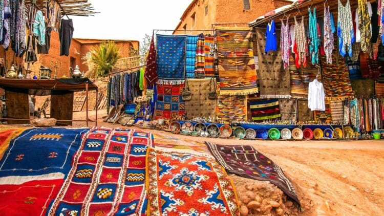 Étal de tapis et d'artisanat traditionnel dans un souk au Maroc.