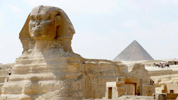 Le Grand Sphinx de Gizeh avec une pyramide en arrière-plan.