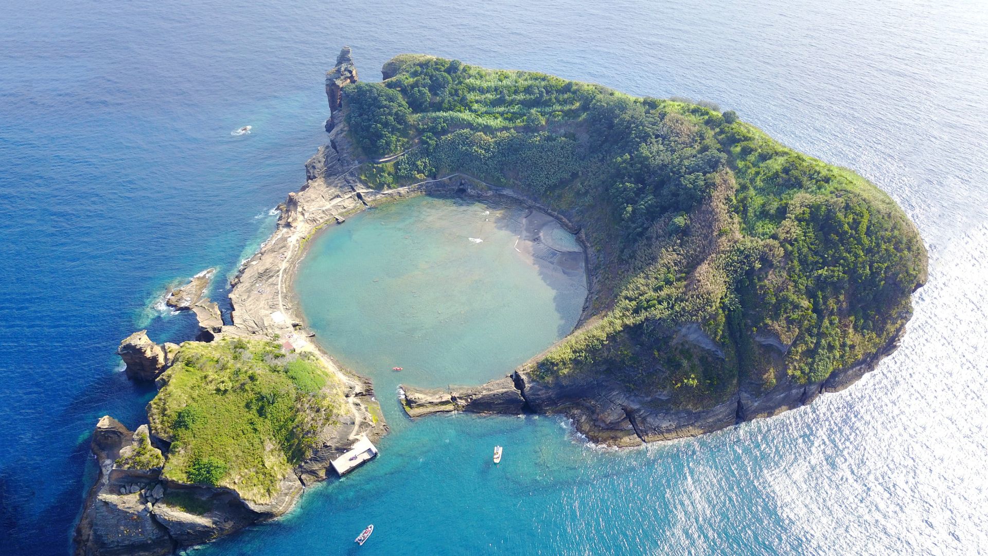 Îlot volcanique entouré d’un lagon aux eaux turquoise dans une destination insulaire.