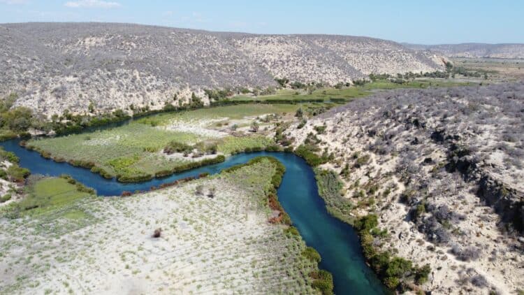 Vue aérienne d’une rivière serpentant dans une vallée aride de Madagascar.