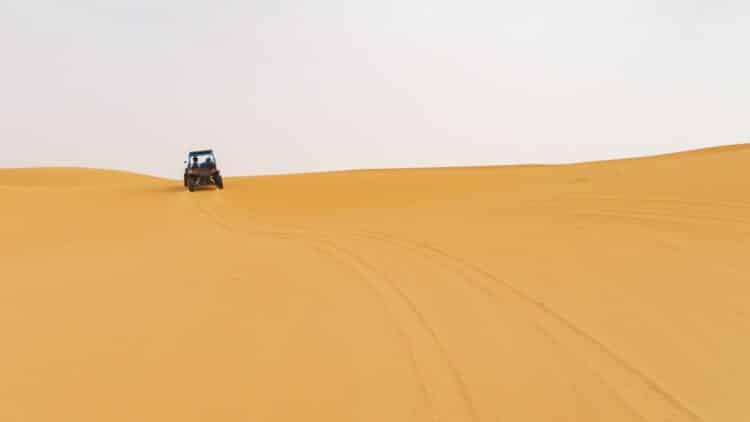 Véhicule tout-terrain roulant sur les dunes du désert marocain.