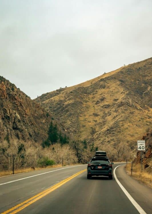 Voiture sur une route de montagne lors d'un autotour au cœur de paysages sauvages.