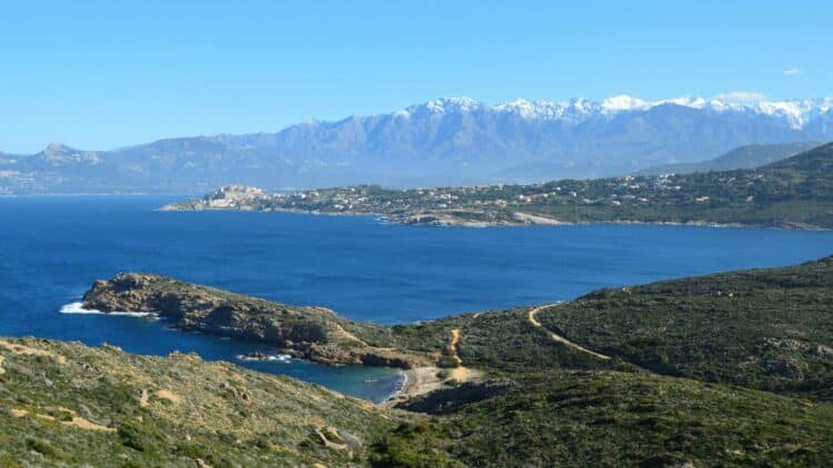 Paysage de la Balagne en Corse entre mer turquoise, maquis et montagnes.