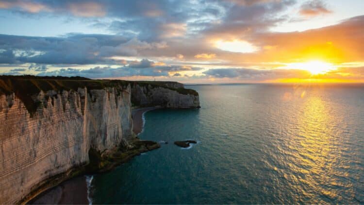 Falaises blanches d'Étretat au coucher du soleil sur la côte normande.