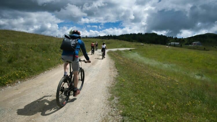 Cyclistes parcourant un chemin au cœur des paysages naturels de Bretagne.