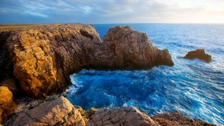 Falaises rocheuses plongeant dans les eaux turquoise des Baléares.