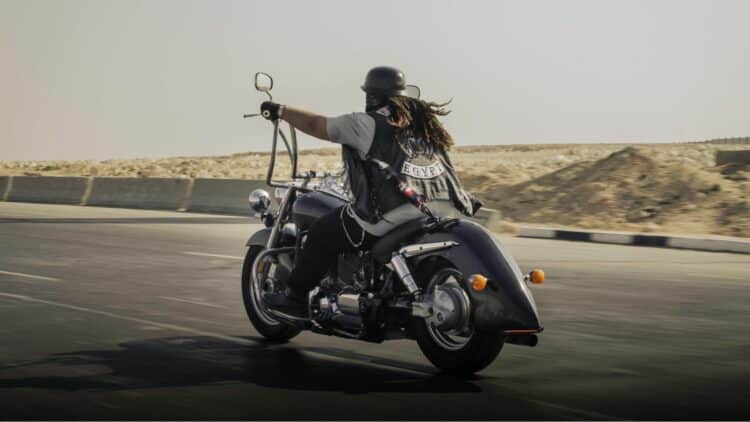 Motard roulant en Harley-Davidson sur une route désertique.