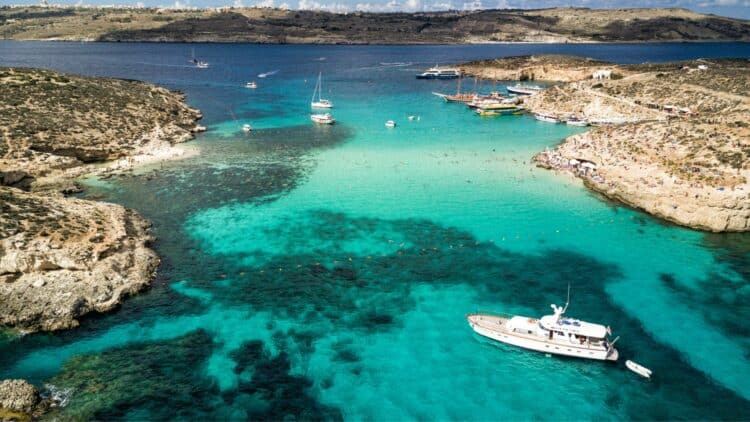Vue aérienne du Blue Lagoon à Comino avec ses eaux turquoise et ses bateaux.