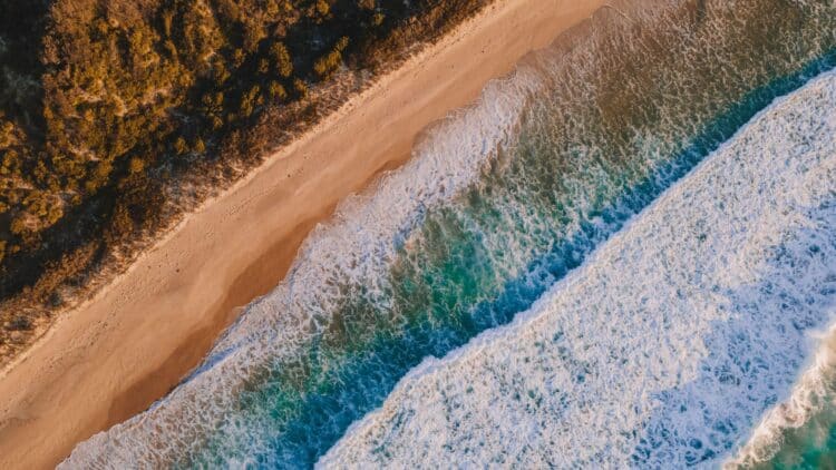Vue aérienne d'une plage australienne bordée par l'océan.