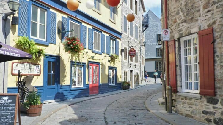 Rue pavée du Vieux-Québec bordée de maisons colorées.