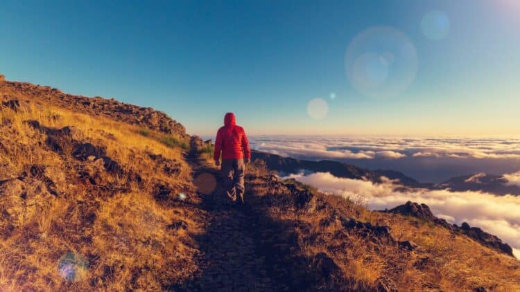 Randonneur sur un sentier de montagne au-dessus des nuages à Madère.