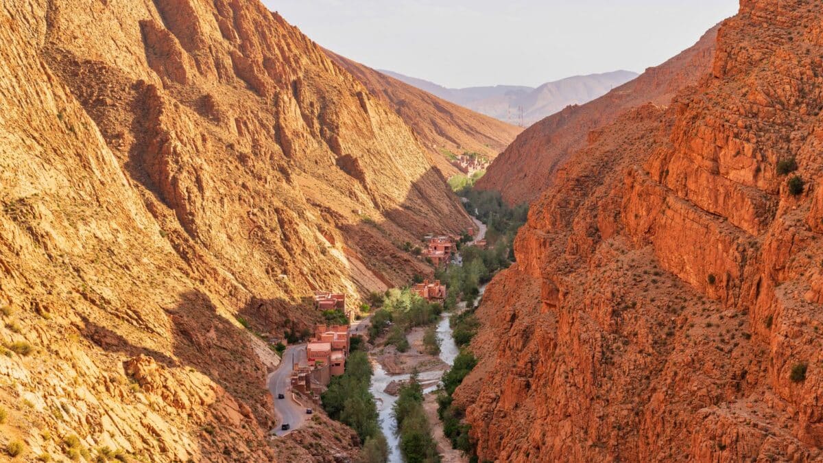 Paysage rocheux de la vallée du Dadès au Maroc traversé par une rivière et une route.