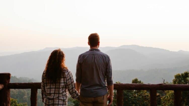 Couple admirant un paysage de montagnes lors d'un voyage.