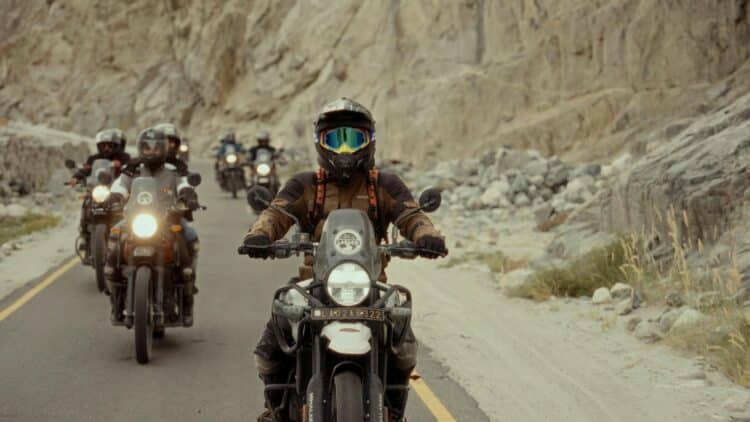 Groupe de motards traversant une route de montagne lors d'un voyage à moto.